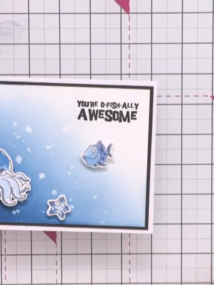 Step 13: Attach the die-cut sea creatures to your card using foam pads, positioning them to appear as if swimming out f