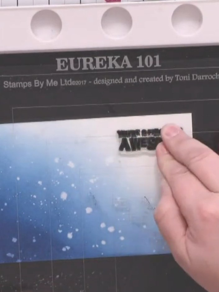 Step 9: Stamp your chosen sentiment in the lighter area of the blended background using midnight black ink. Position t
