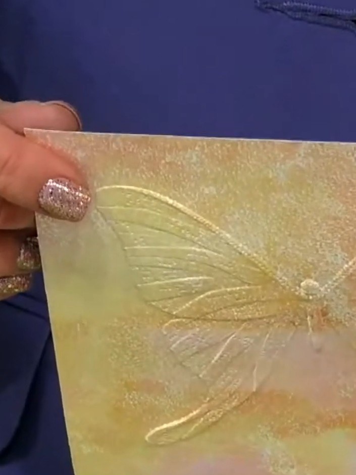 Step 3: Carefully lift and remove the embossed paper from the die to reveal the detailed butterfly texture. The emboss