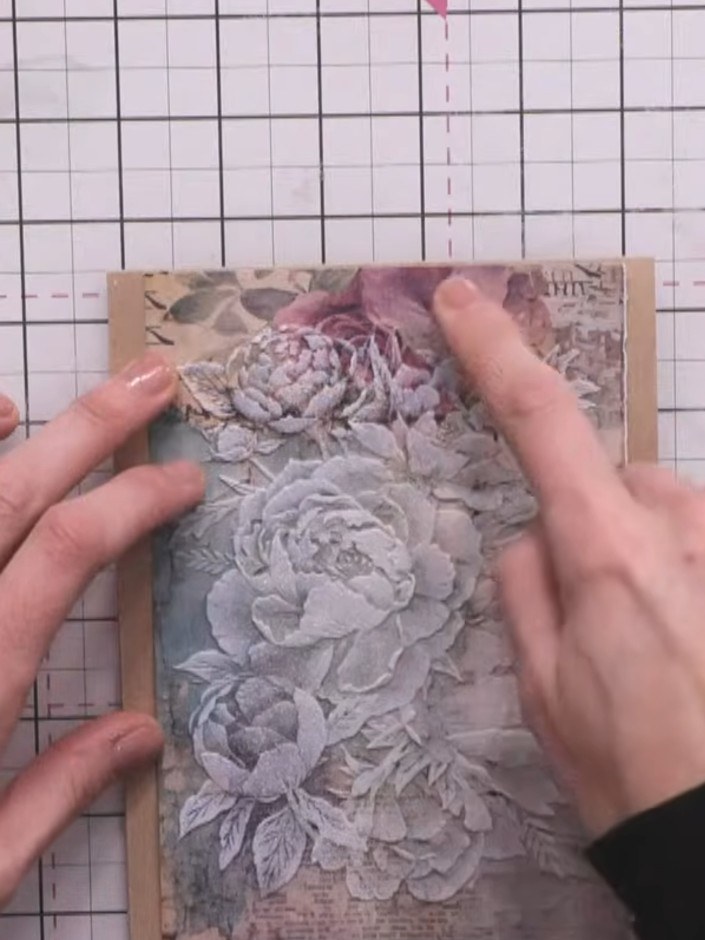 Step 5: Layer the embossed floral piece onto complementary patterned paper. Position it centrally and smooth it down t