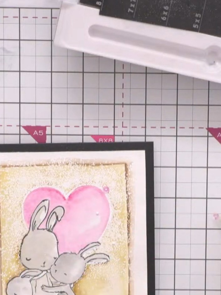 Step 14: Add pink sequins or sparkles to embellish the card, placing them strategically around the heart and bunny desi