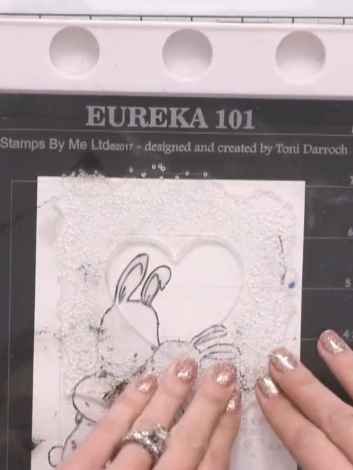 Step 6: Stamp the frame design again using a sticky ink pad. Apply white embossing powder over the stamped image, then