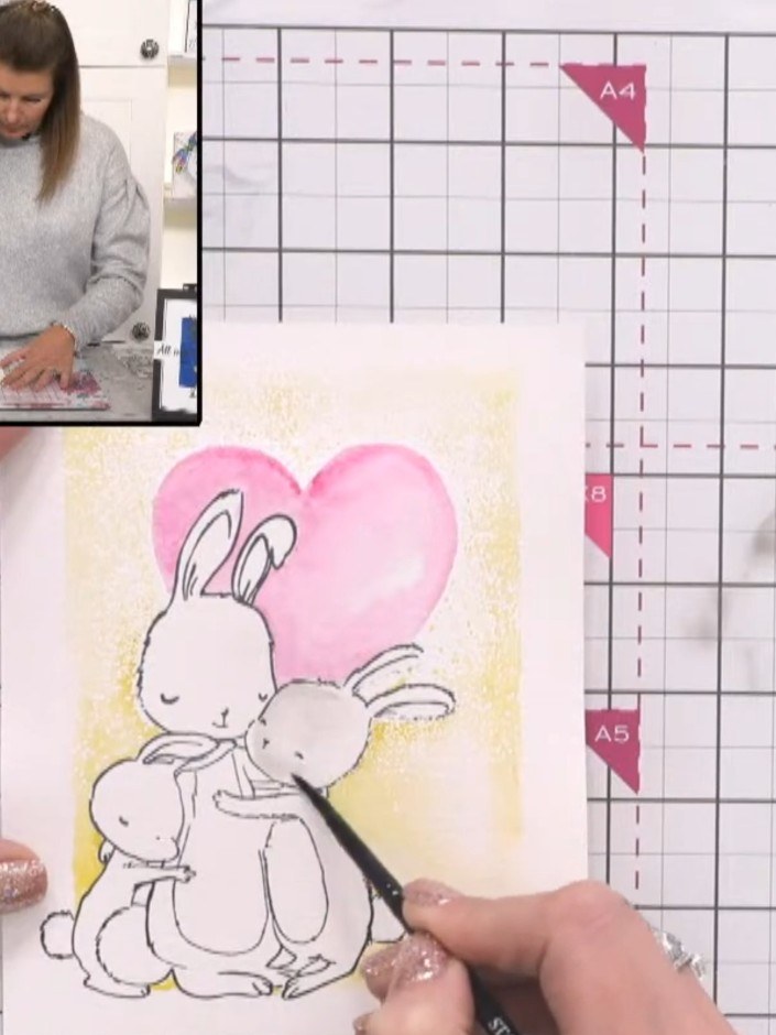 Step 9: Colour the bunnies with grey watercolour paint. Use a damp brush to dab and lift colour, creating texture for 