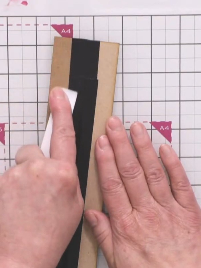 Step 6: Roll the lid back to test the mechanism works smoothly. Push the black and kraft striped panel down gently to 