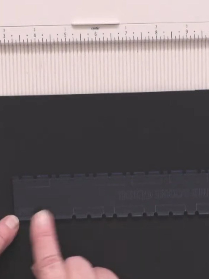 Step 3: Place your black cardstock into the scoring tool, positioning it against the guide marks at the bottom of the 