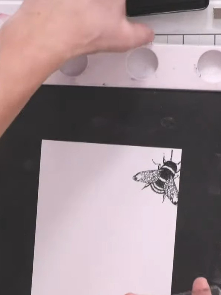 Step 1: Ink up the smaller bee stamp from the Queen Bee A5 stamp set with black ink using your stamping platform.