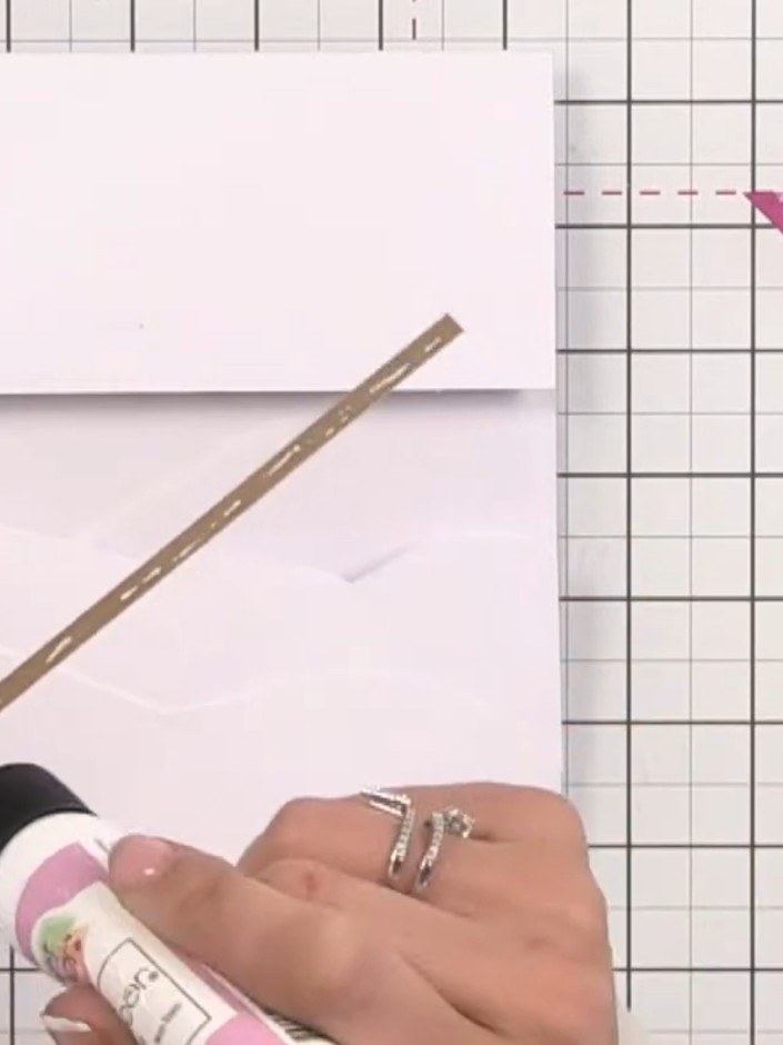 Step 7: Cut a thin strip of gold card and apply glue to the back using a glue pen. Position the gold strip along the e