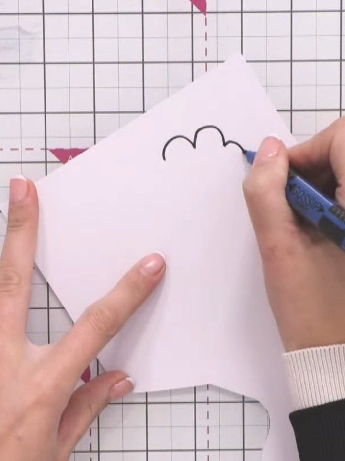 Step 1: Using a black pen, draw fluffy clouds freehand on white cardstock. Create various sizes in a loose, organic st