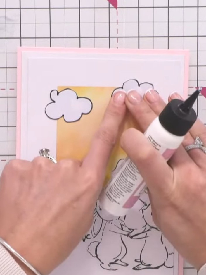 Step 16: Arrange the hand-drawn clouds on your card, placing some flat on the surface and positioning others to overlap