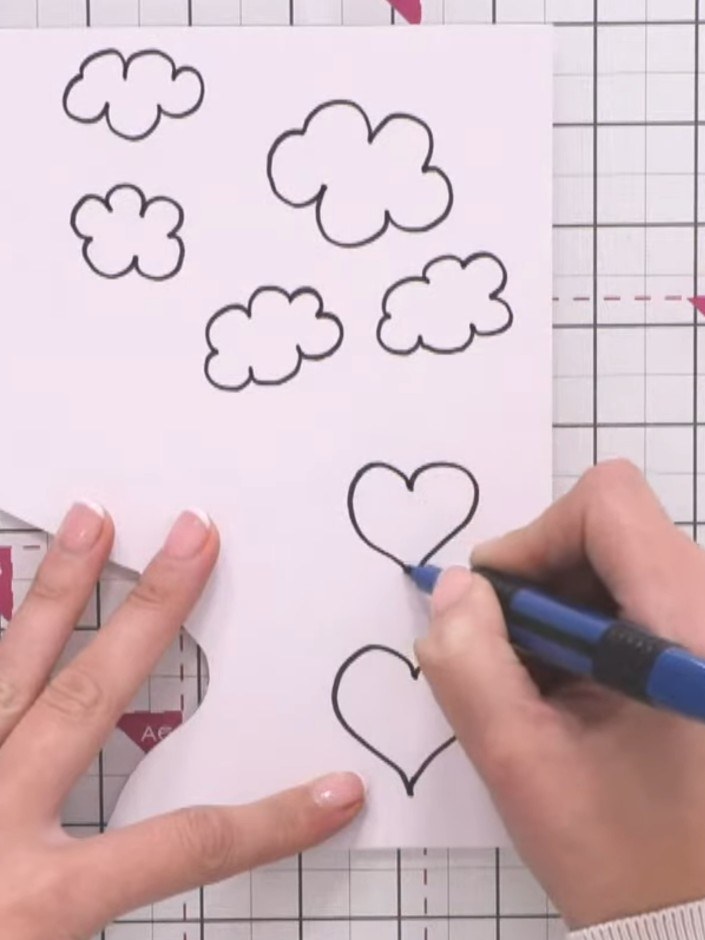 Step 2: Draw a heart shape freehand with a black pen on the pink paper. Make the outline fairly thick to help with fus