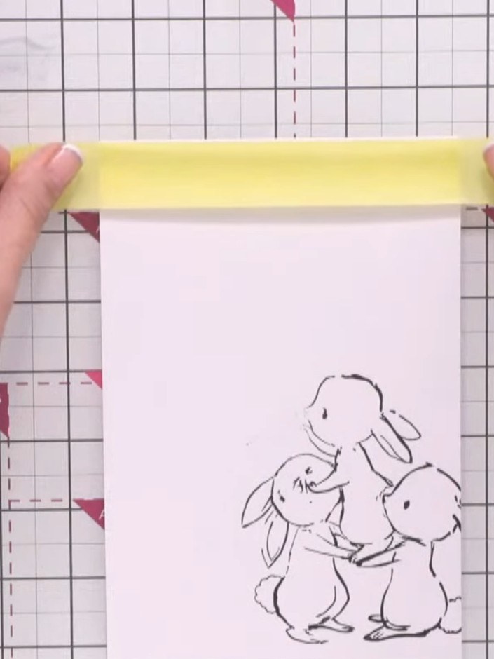 Step 9: Position strips of yellow masking tape horizontally across the top and bottom of your stamped image to create 
