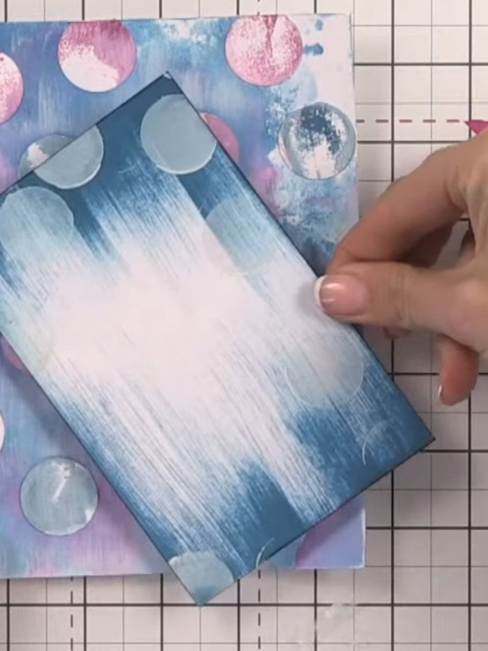 Step 11: Adhere the blue gradient bunny panel to the decorative background card, positioning it centrally. Then mount t