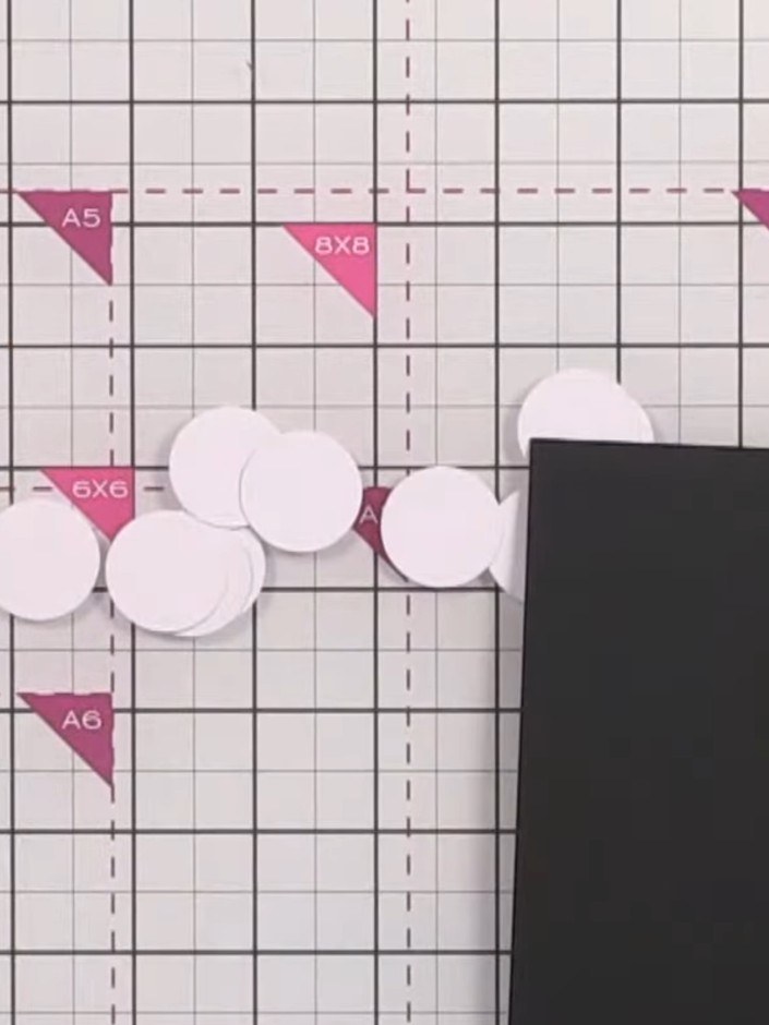 Step 6: Arrange the punched white circles around the edges of your card base, leaving some extending off the page and 