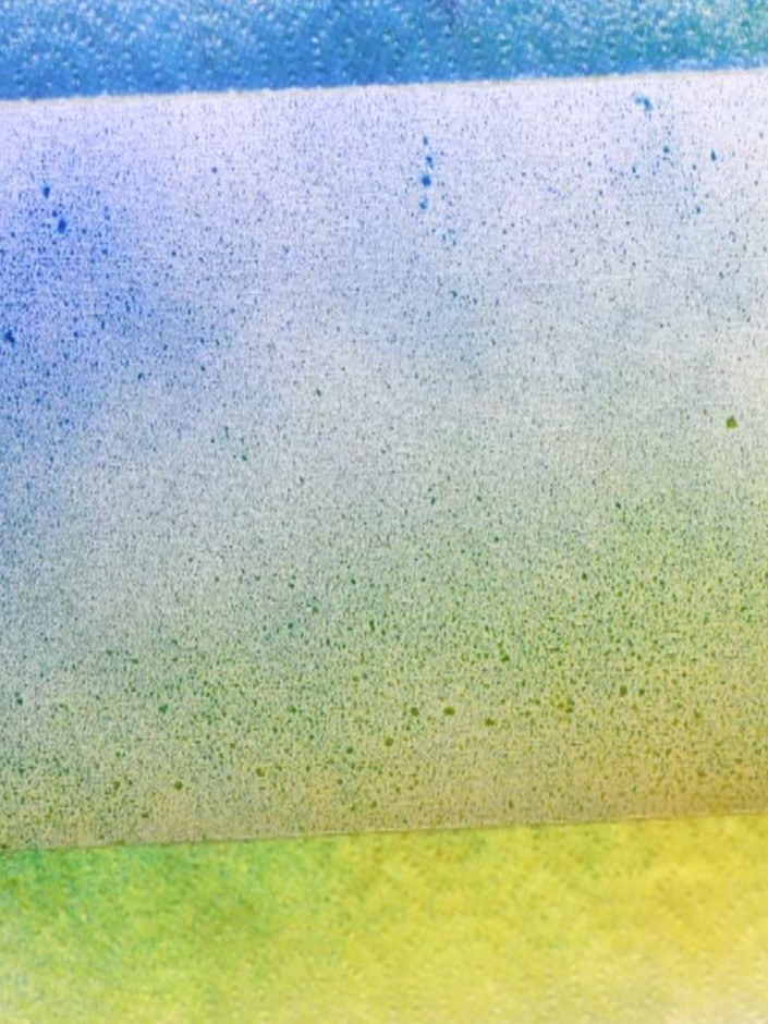 Step 2: Spray yellow ink onto the lower section of the card. Then spray blue ink from the top, blending downwards to c