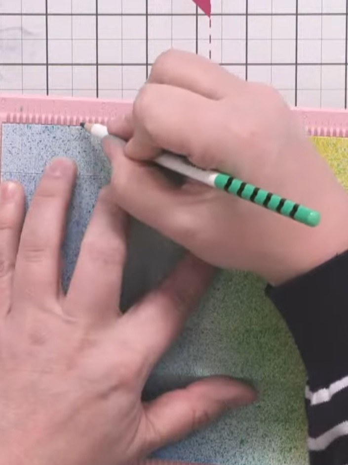 Step 7: Using a pencil and the scoring mat as a ruler, mark half-inch increments along the length of the glitter card 