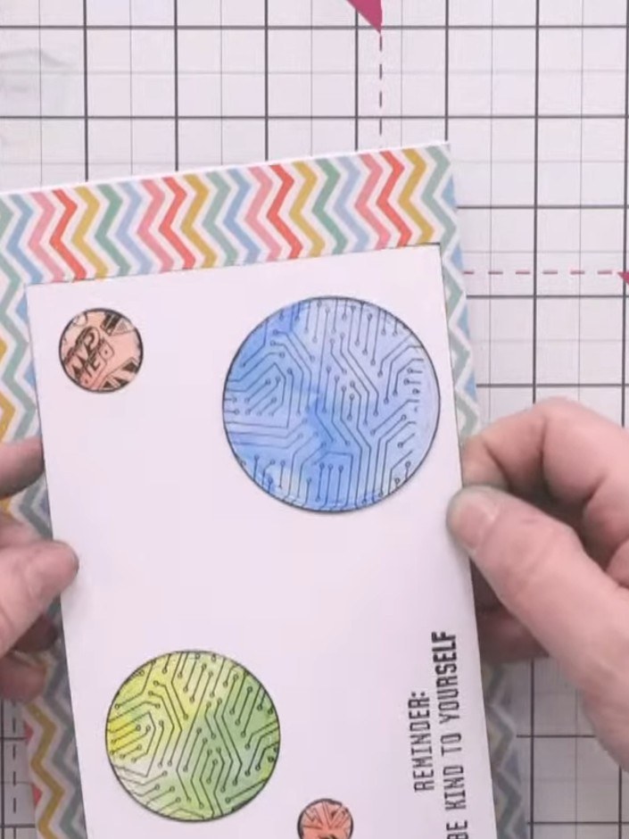 Step 11: Attach the die-cut circles flat to the card front using glue. Position the blue circle at the top and the yell