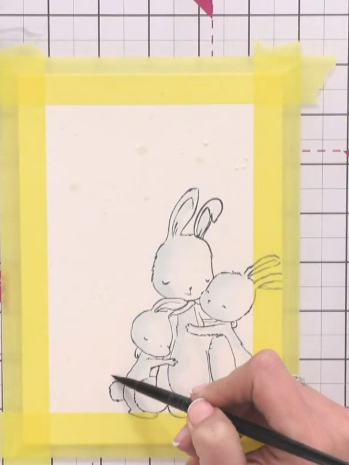 Step 7: Using a clean paintbrush and water, wet the background area of your card around the stamped bunnies, being car