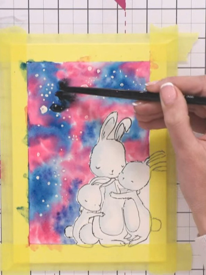 Step 9: Add black watercolour to the galaxy background using a paintbrush to intensify the darker areas and create con