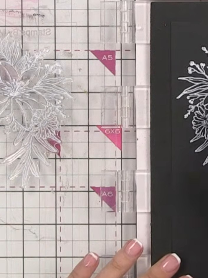 Step 4: Carefully lift the stamp straight up from the black card to reveal the crisp white floral image. The white ink