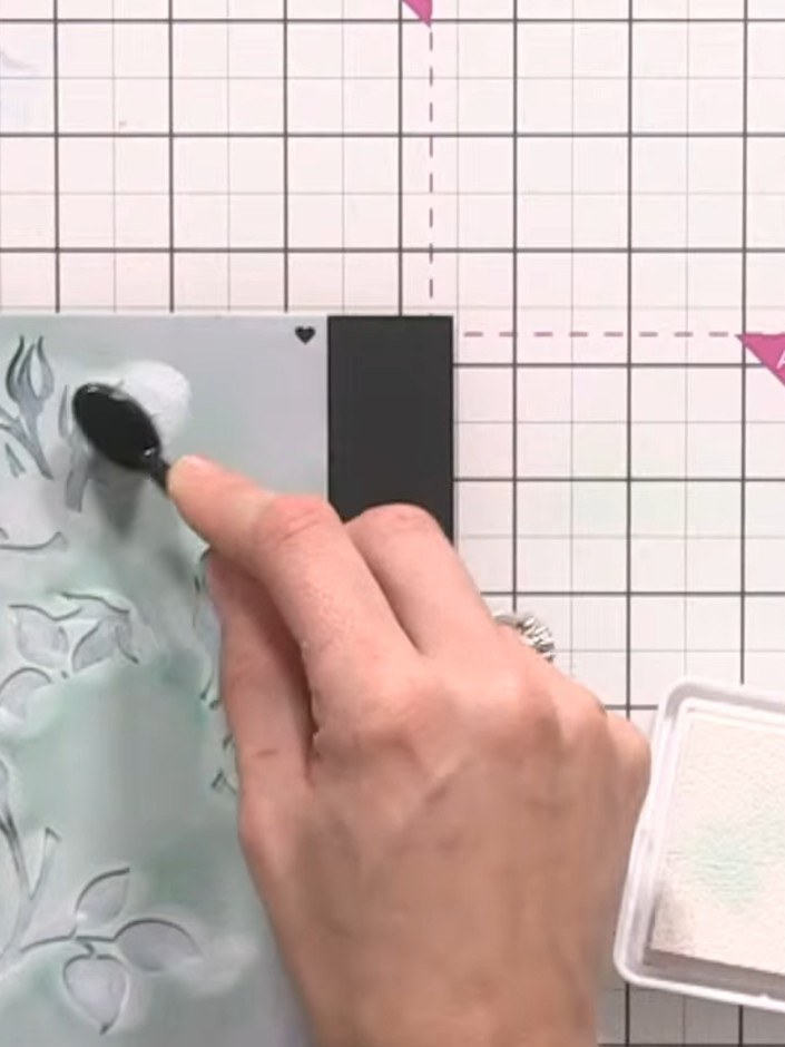 Step 7: Position stencil number five (the leaves) over your black card and apply white ink through the stencil using a