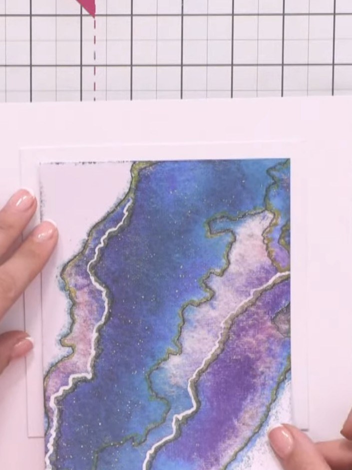 Step 4: Trim a piece of the blue and purple watercolour patterned paper to fit within the aperture on your white card 