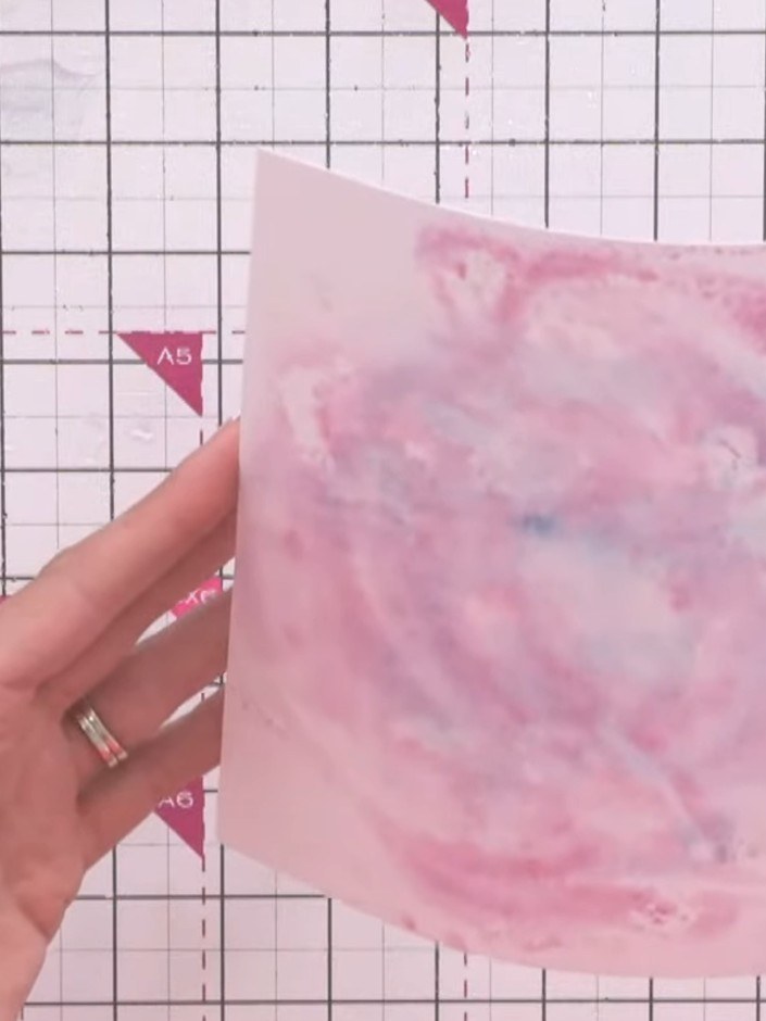 Step 8: Add ink splats around the edges of the pink watercoloured base layer using a brush or spattering tool to creat