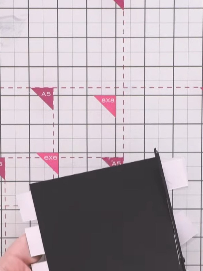 Step 5: Trim the excess edges of the striped paper strips flush with the black card base using scissors.