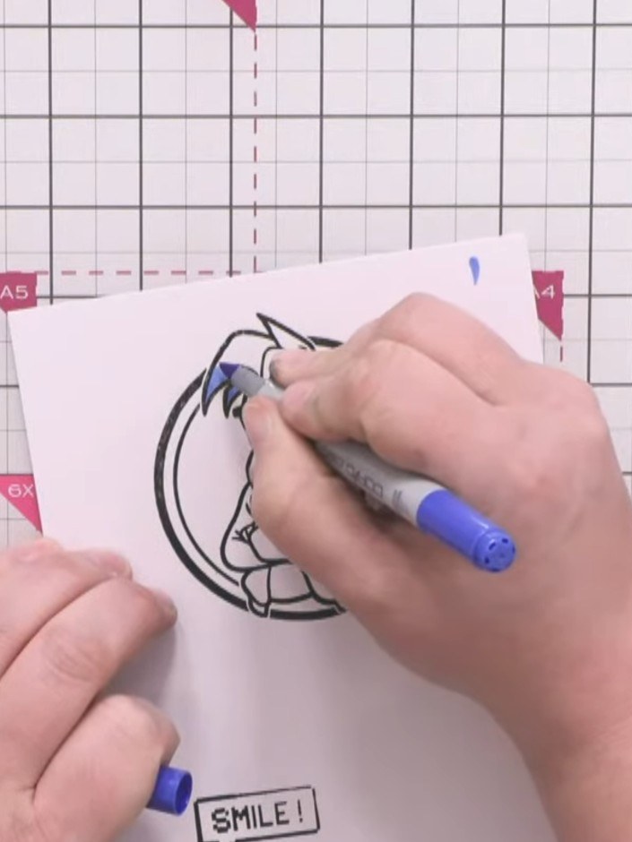 Step 8: Colour the Crash character using alcohol markers. Apply blue to the hair and t-shirt with darker blue shading,