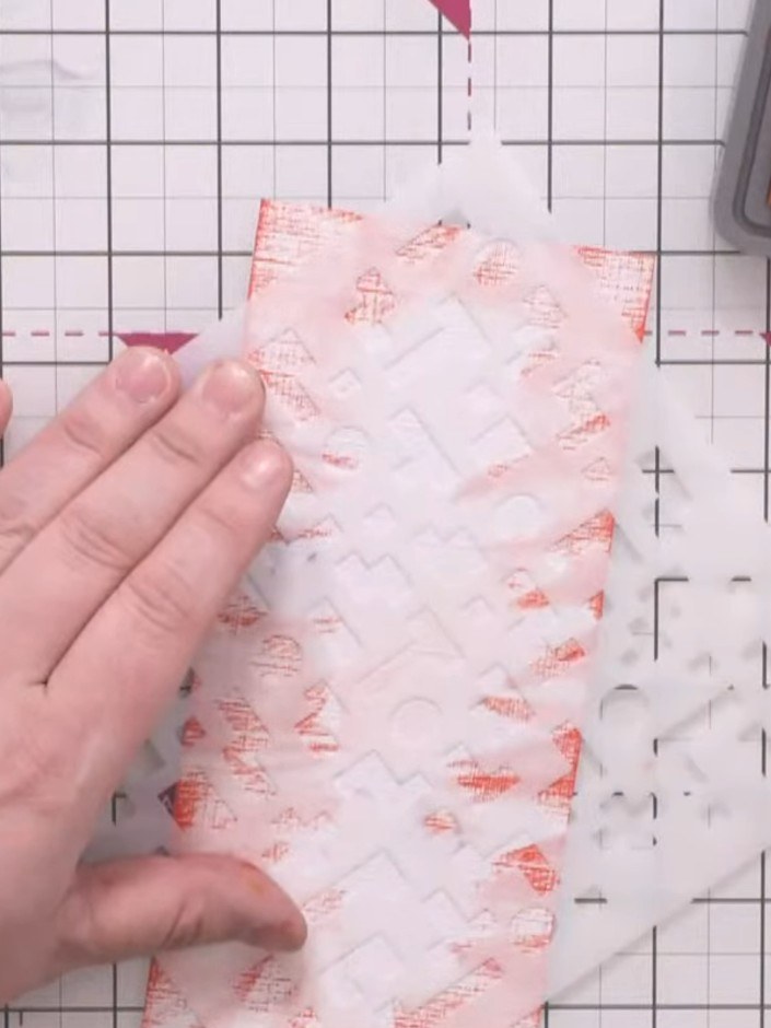 Step 3: Position the pixel pattern stencil over the centre of the card panel. Using a sponge dauber, lightly dust red 