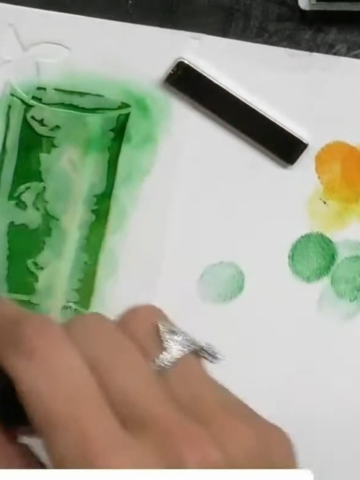 Step 4: Apply green ink through the second stencil layer, building up colour and dimension around the glass image. Use