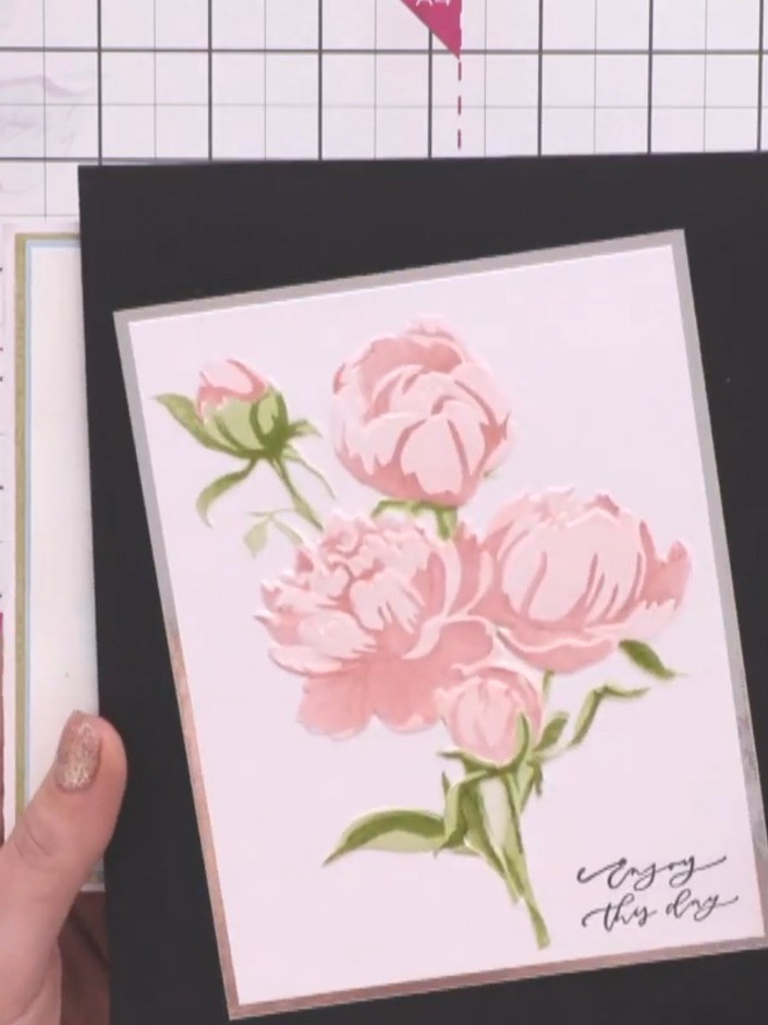 Step 4: Layer the pink peony panel with the gold border onto the black card base. Position it centrally to create an e