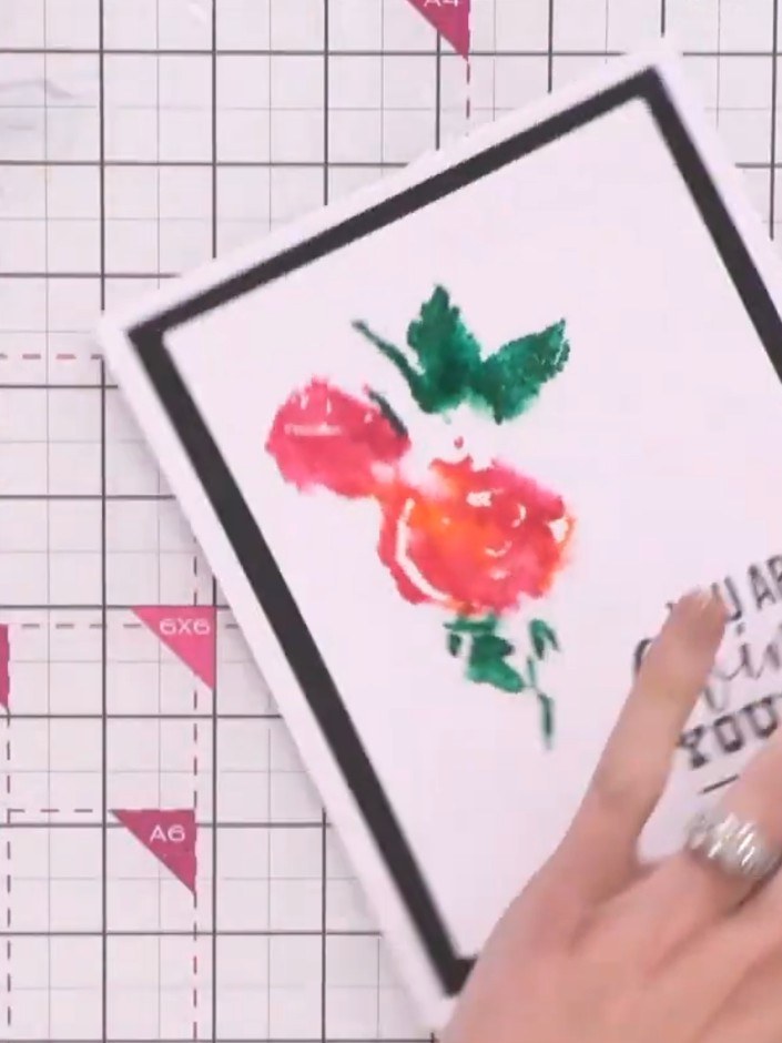 Step 4: Press the stamped watercolour rose design firmly onto your white card base with the black frame border, positi