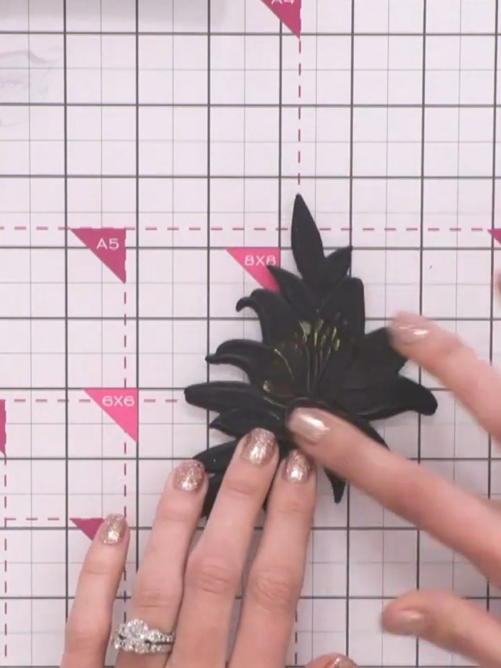 Step 5: Apply gold ink or polish to selected areas of the black embossed floral piece to highlight the detail and add 