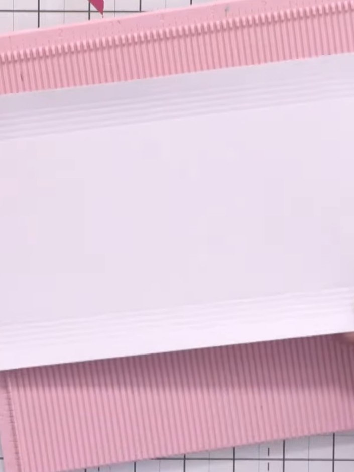 Step 3: Score five vertical lines down the white card panel, then rotate it 90 degrees and score five horizontal lines