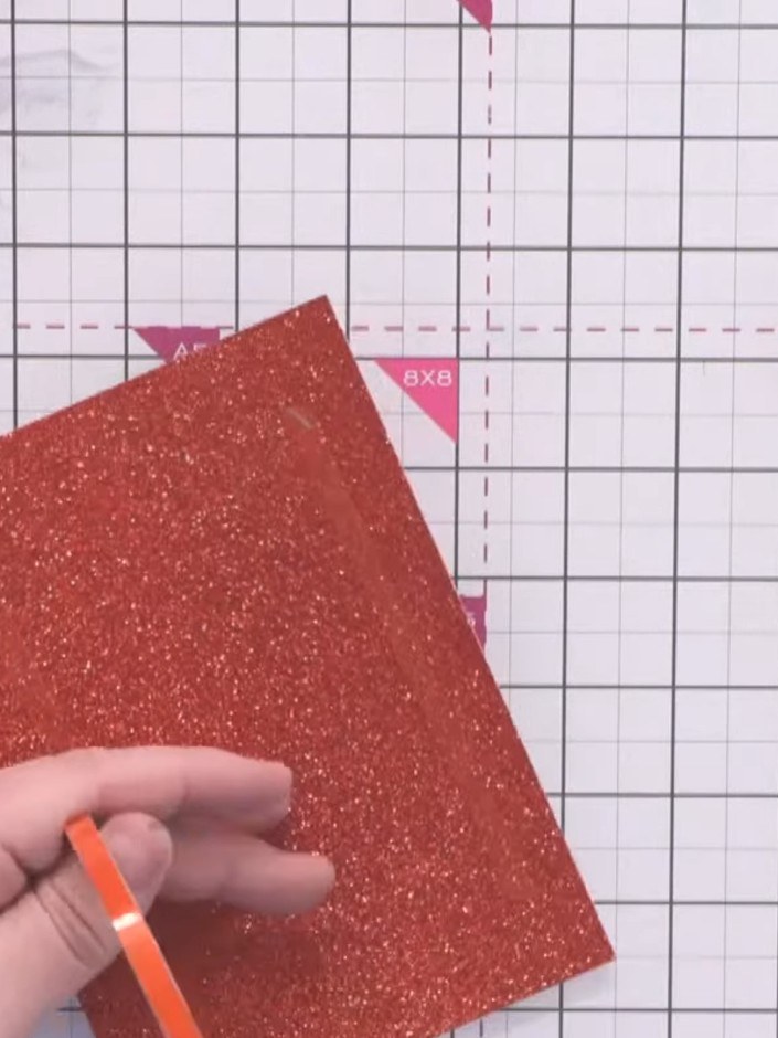 Step 3: Mount the sprinkle background onto red glitter card using red line tape, positioning it centrally.