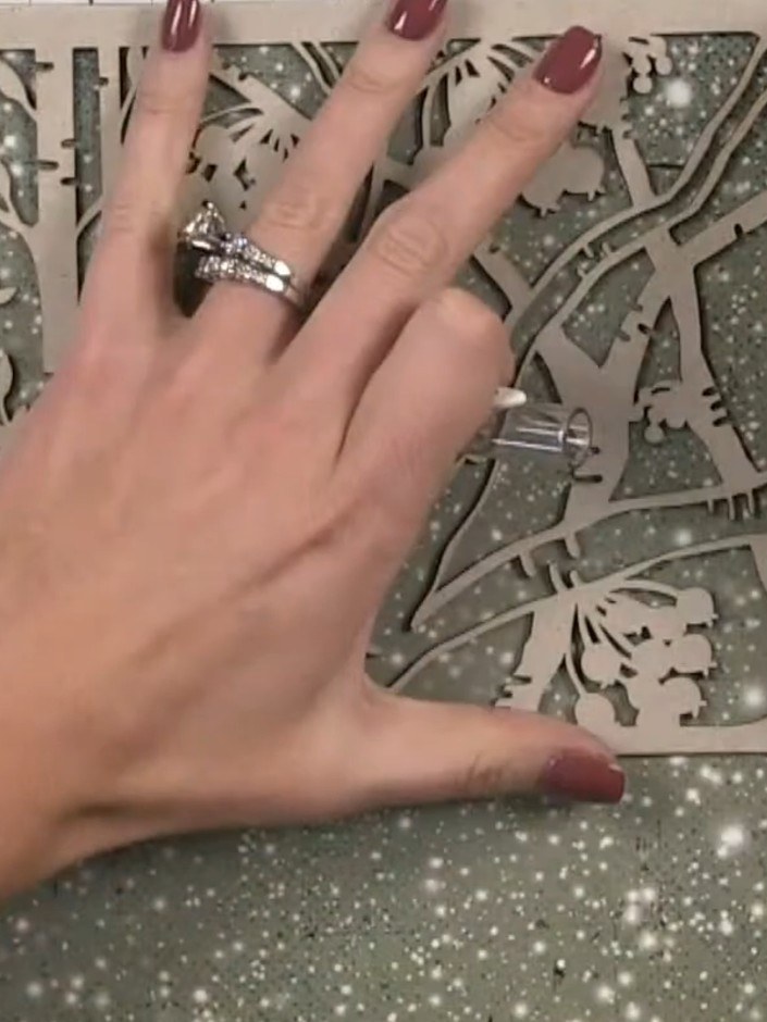Step 10: Select a decorative paper from your kit and position it over the front cover. Hold it in place with one hand w