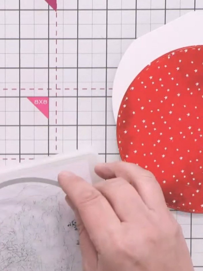 Step 5: Adhere the red patterned paper circle to the inside of the bubble card base. Leave the top corner unglued as y