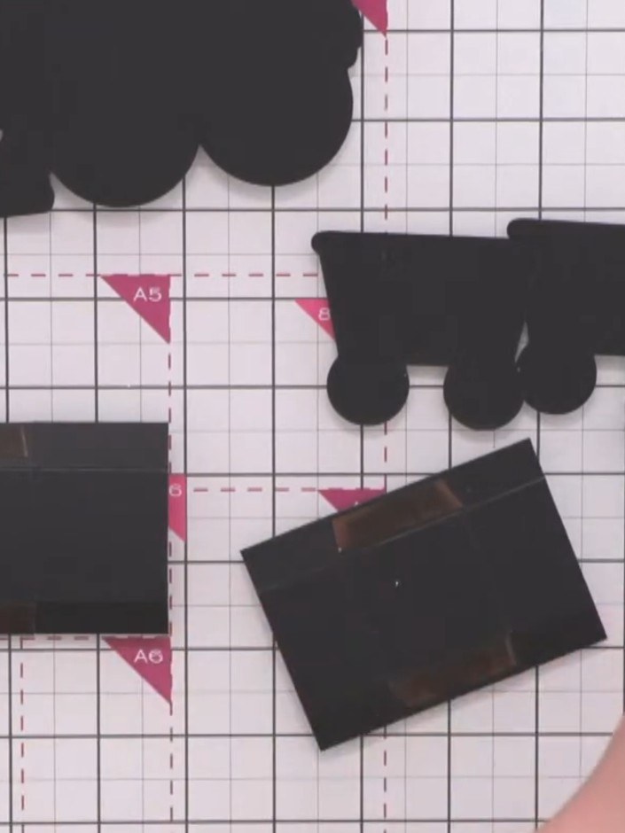 Step 11: Apply red liner tape to the edges of the black carriage base pieces. Trim off any excess tape with scissors.