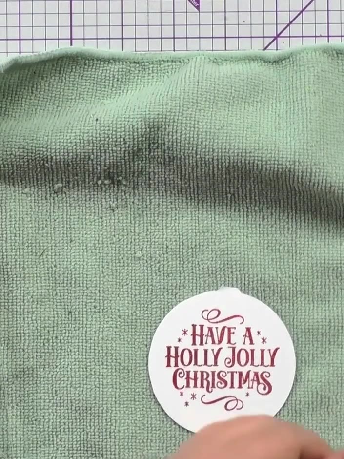 Step 4: Stamp the 'Have a Holly Jolly Christmas' sentiment onto your white circle using red ink. Position the stamp ce