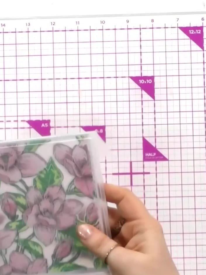 Step 10: Place the stamped and coloured magnolia piece into the embossing folder, ensuring it is positioned correctly. 