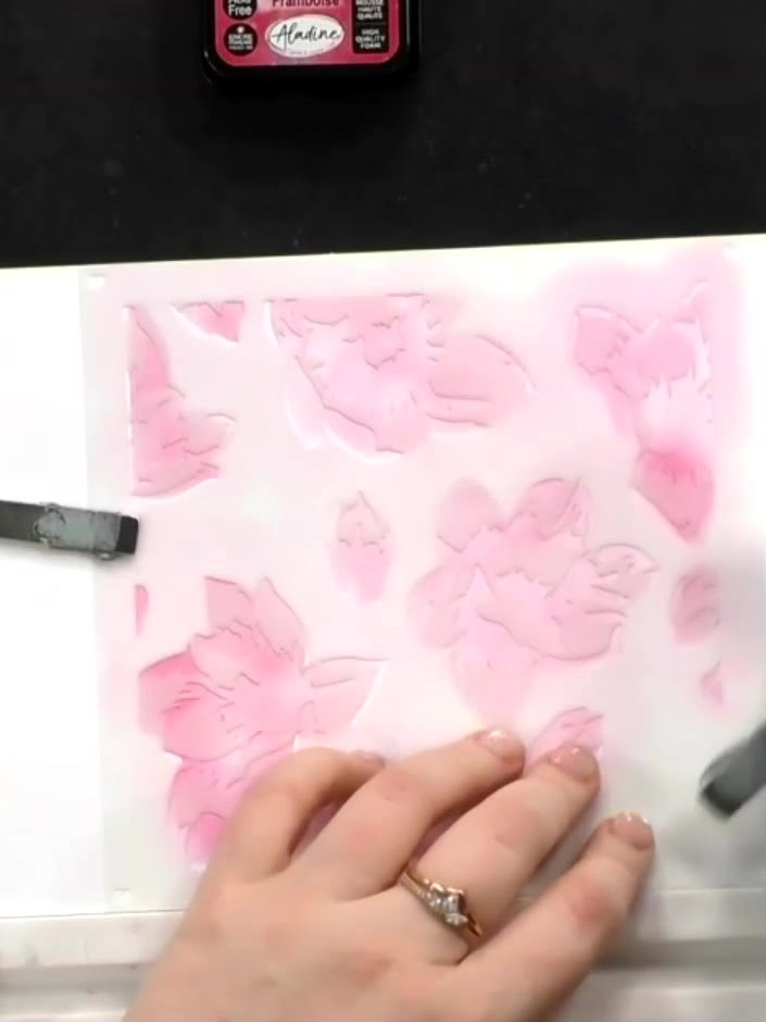 Step 6: Position the third stencil layer and apply a darker pink ink using a blending tool, building up the depth and 