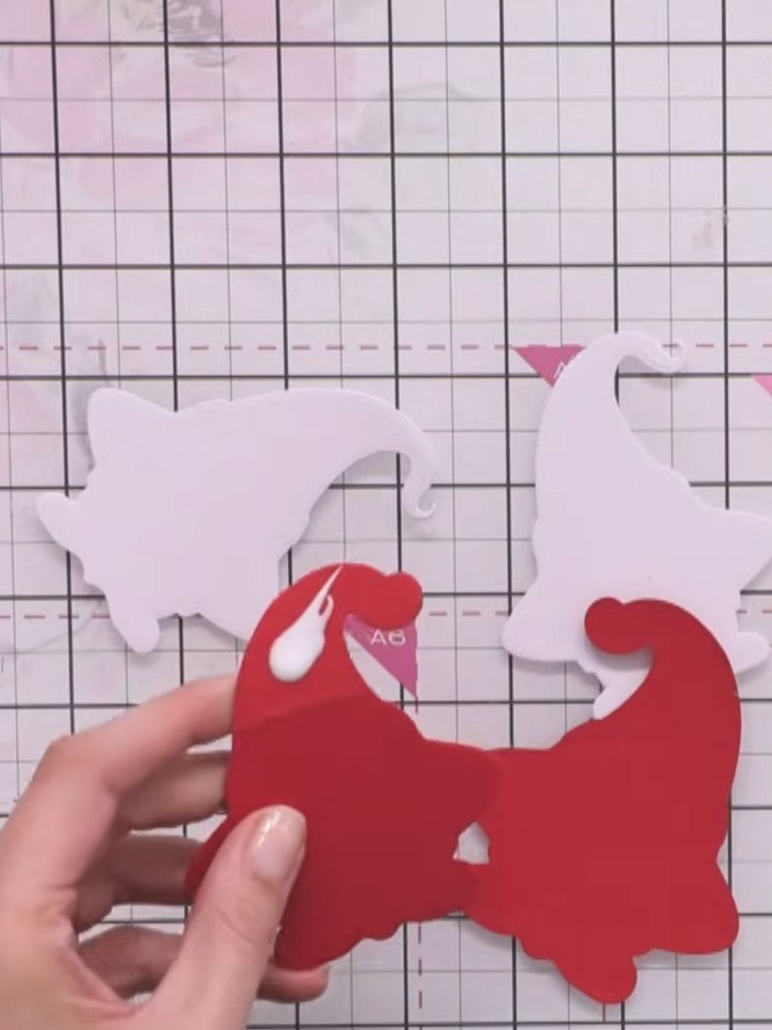 Step 6: Take the two pink outline ghost pieces and score along the back of each one. Fold each piece in half along the