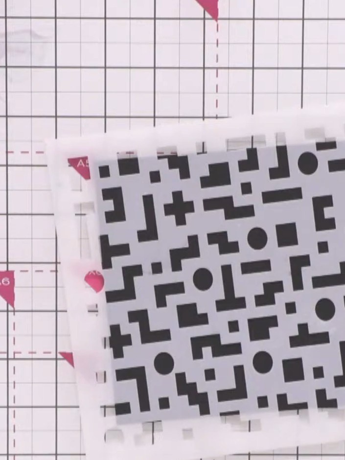Step 1: Place the pixel pattern stencil onto black cardstock at an angle, positioning it slightly off-centre for a mor
