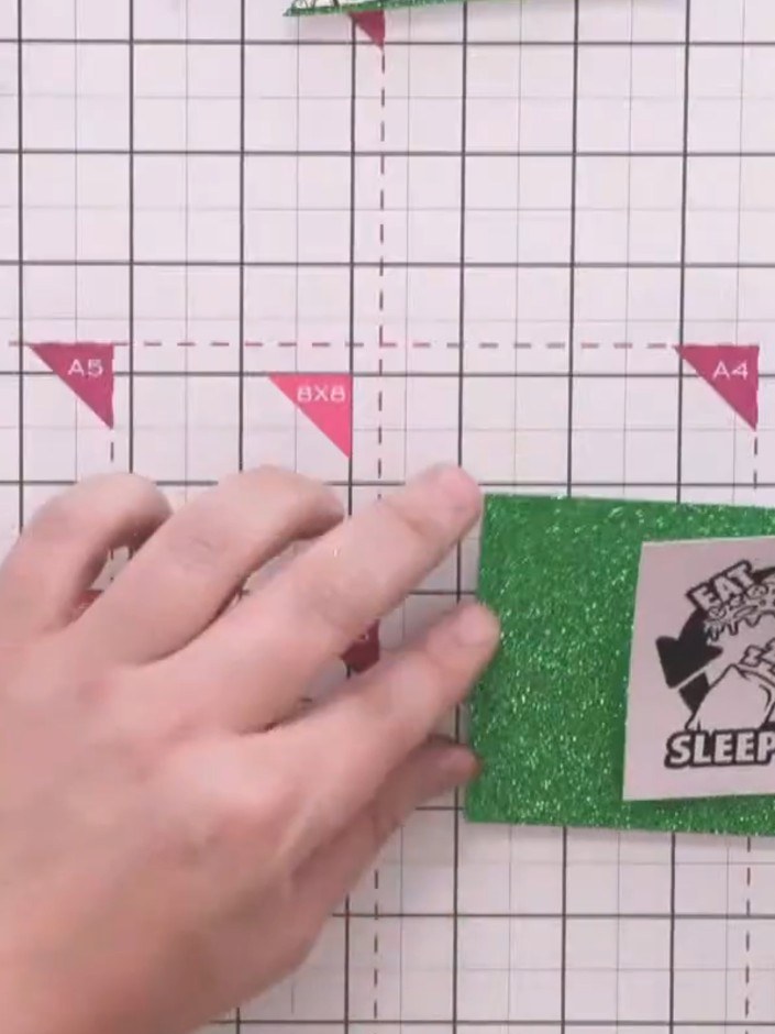 Step 11: Mount the sentiment square onto matching green glitter cardstock using red liner tape for a secure hold.