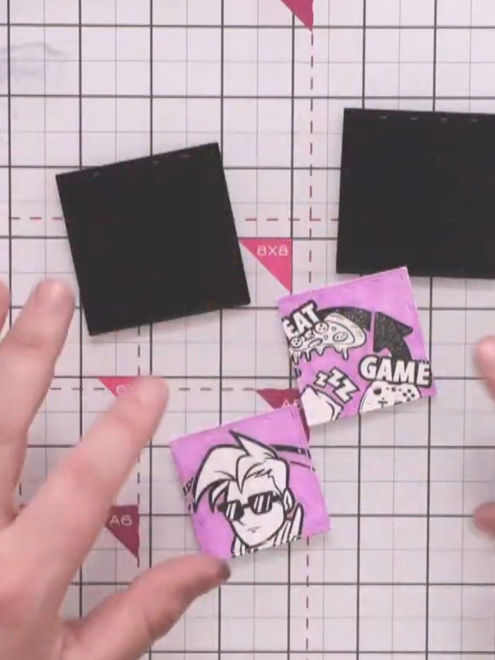 Step 10: Mount each of the three coloured stamped character pieces onto black card matte layers using adhesive to creat