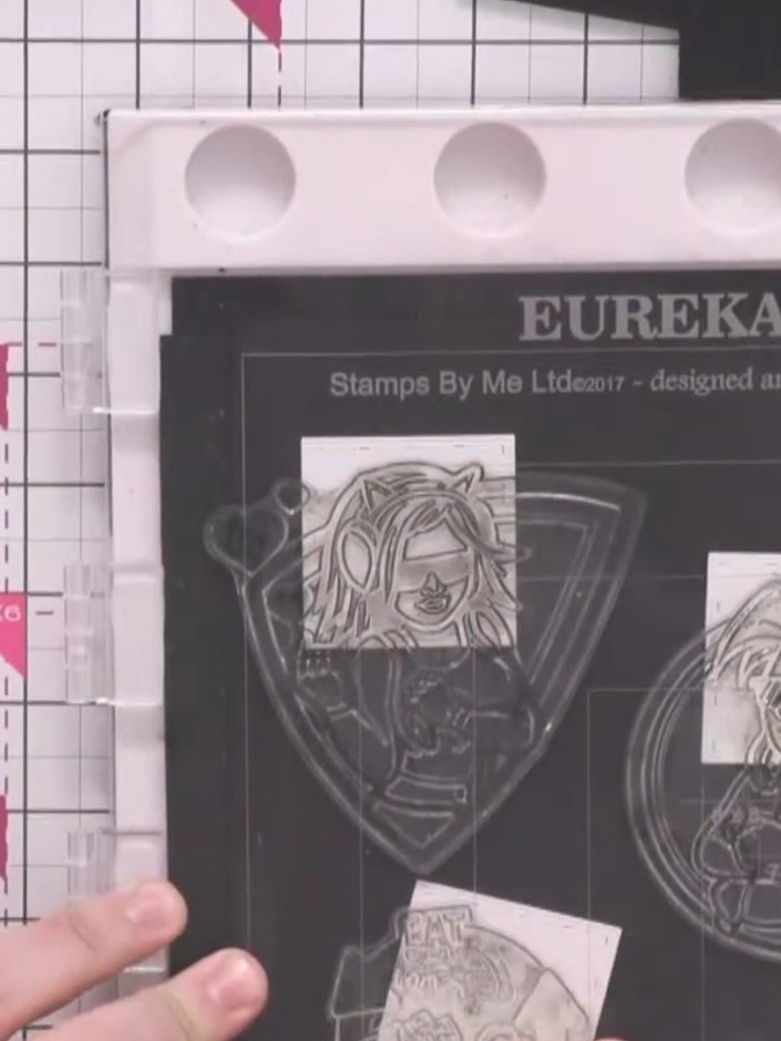 Step 4: Stamp the circular 'eat game and sleep' design in the top corner of the black card using the clear stamp and w