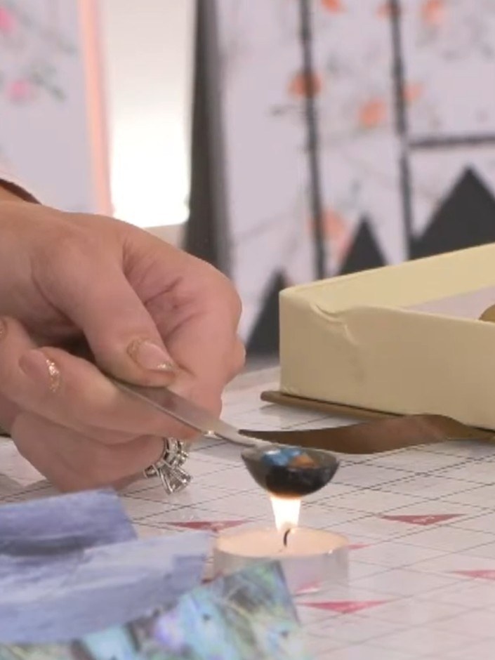 Step 3: Hold the wax stick over the lit candle flame to melt it, allowing the melted wax to drip onto your chosen surf