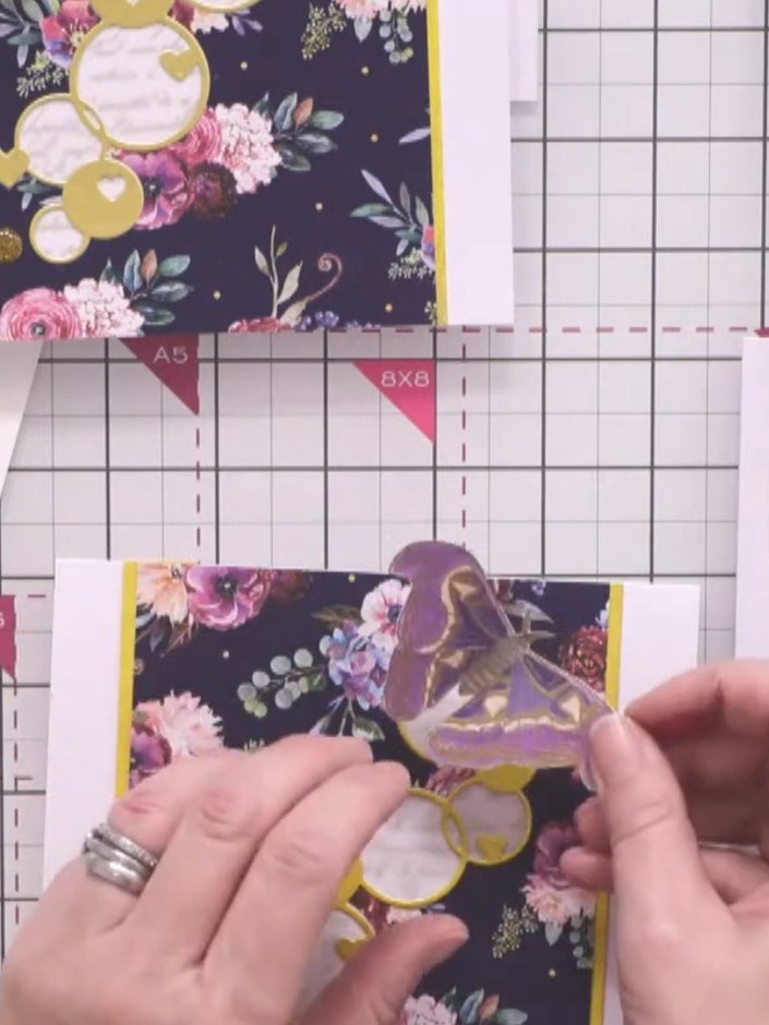 Step 8: Position the gold foiled moth embellishment towards the top corner of the card, angling it diagonally so it ap