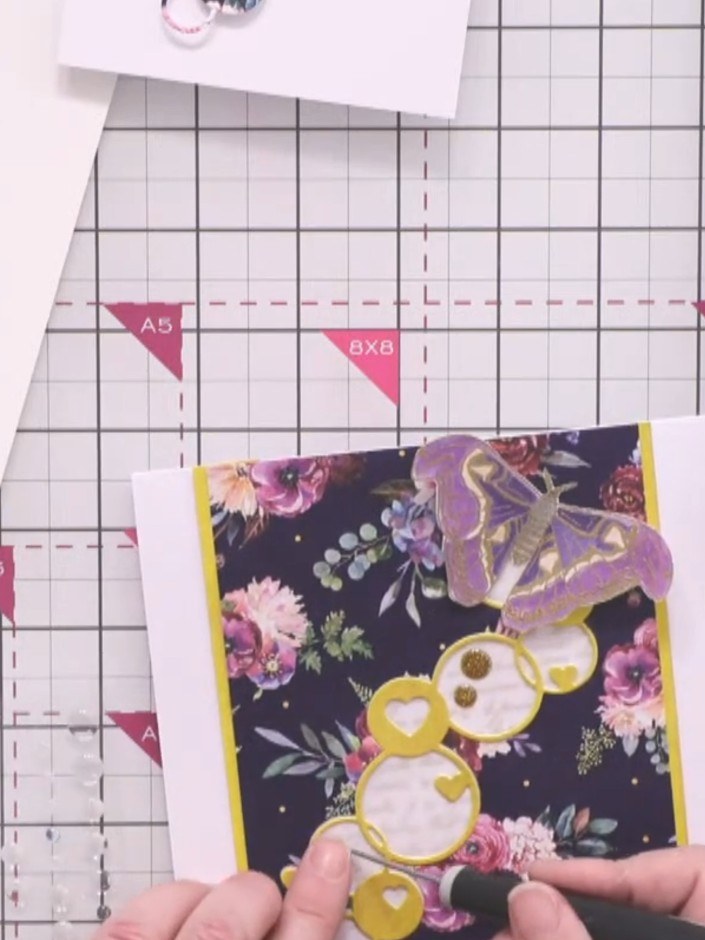 Step 9: Add four gold enamel dots in a diagonal line across the hearts arrangement to create movement and guide the ey