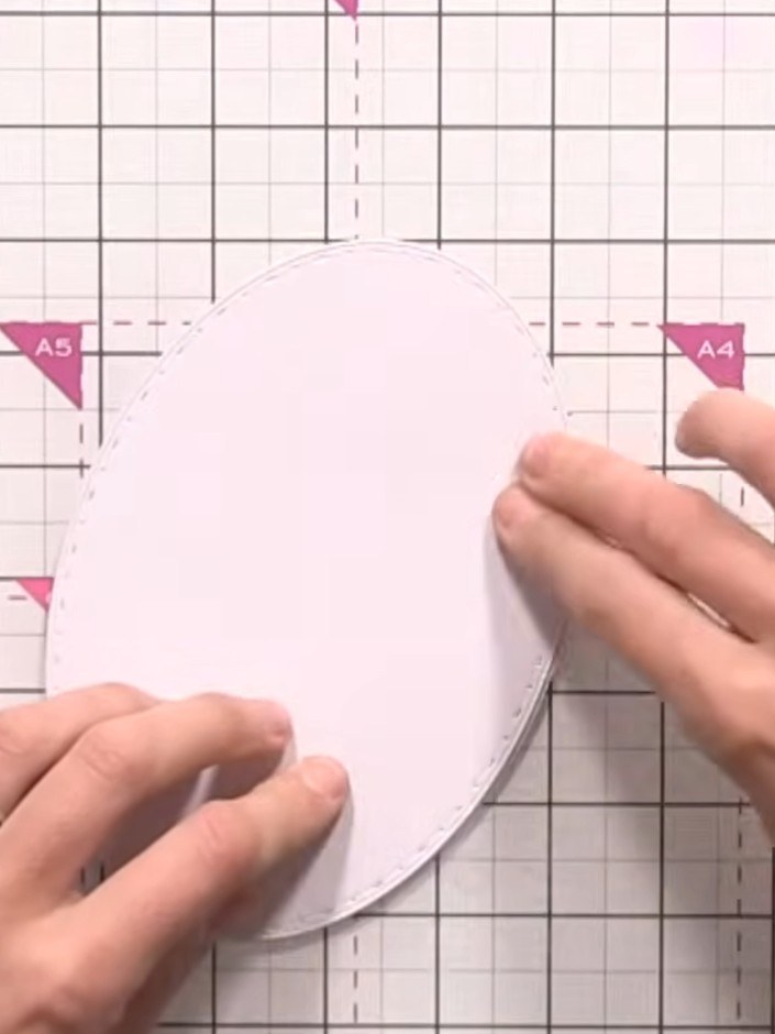 Step 12: Score a line across the top of one oval piece to create a hinge. This will allow the card to open and close.